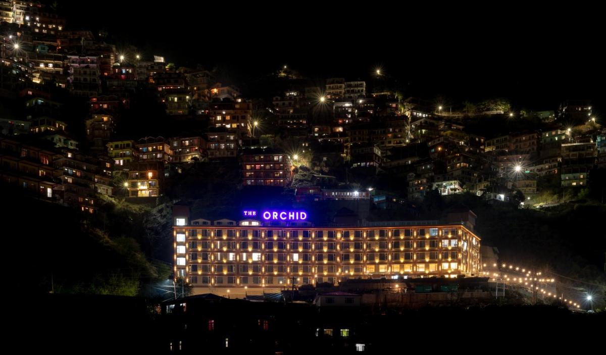 a hotel with a sign on top of it at night at The Orchid Shimla in Shimla