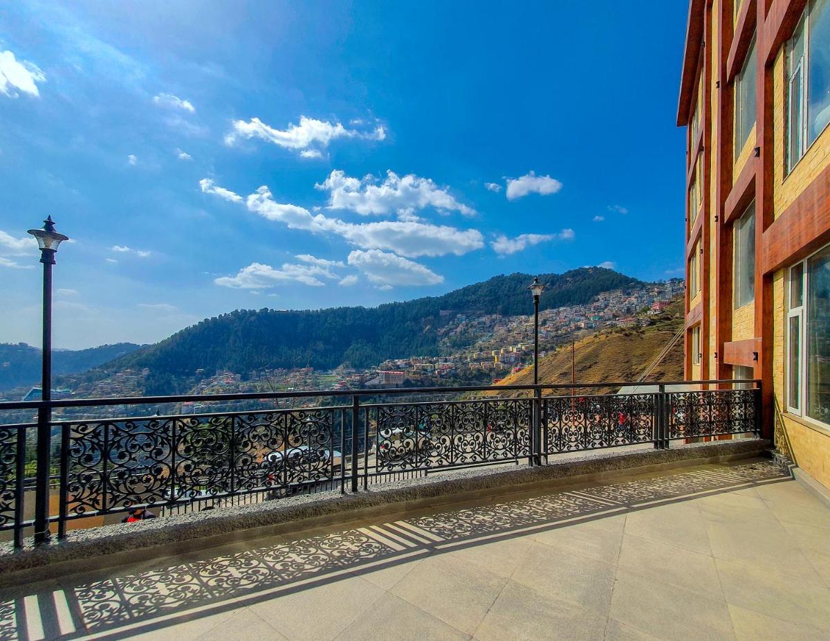 a balcony of a building with a view of a city at The Orchid Shimla in Shimla