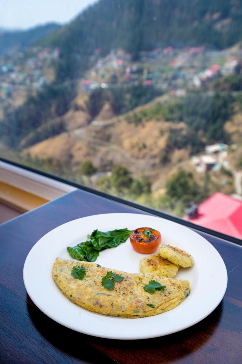 a plate of food on a table with a view at The Orchid Shimla in Shimla