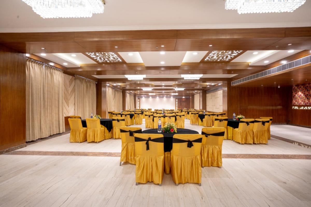 a large banquet hall with yellow chairs and tables at The Orchid Shimla in Shimla