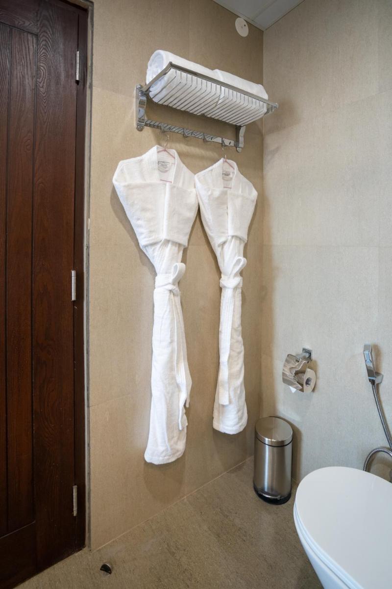 a bathroom with white clothes hanging on a wall at The Orchid Shimla in Shimla