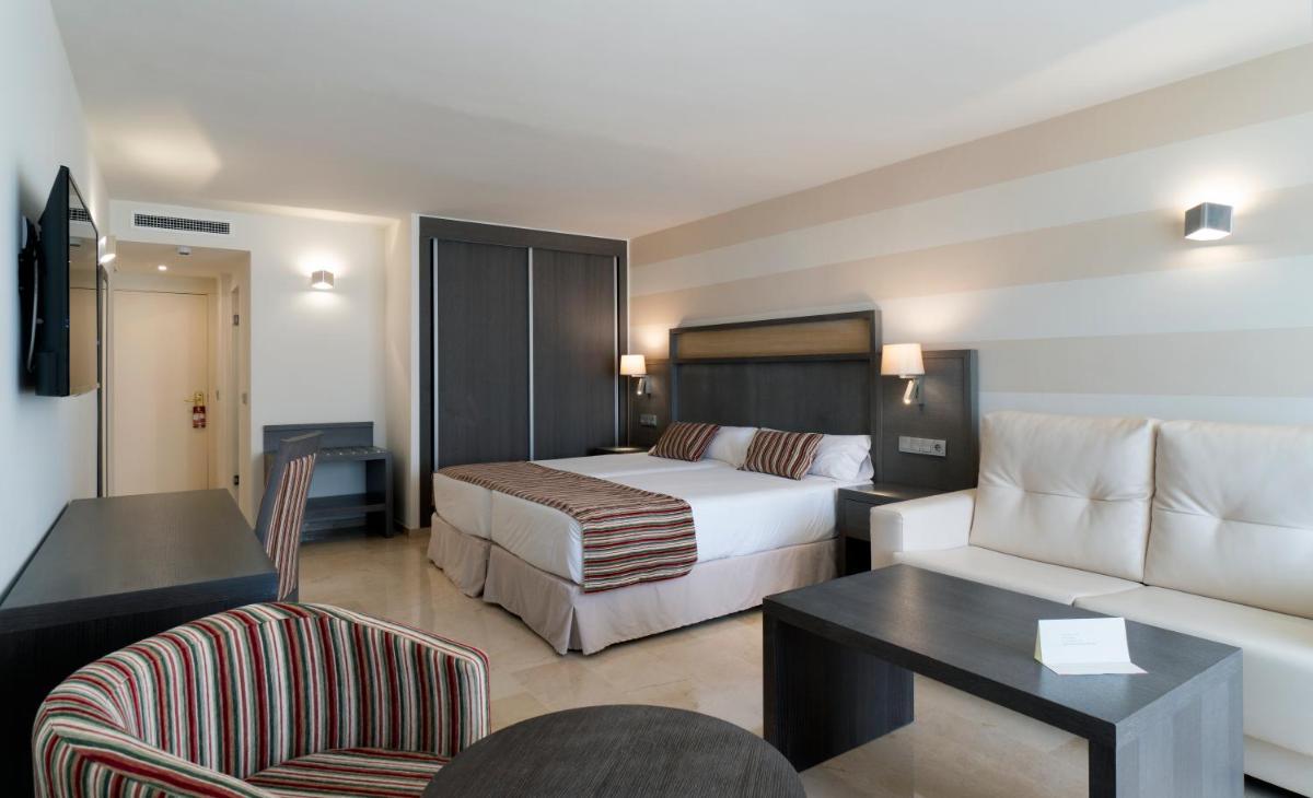 una habitación de hotel con una cama y un sofá en MS Aguamarina Costa del Sol, en Torremolinos
