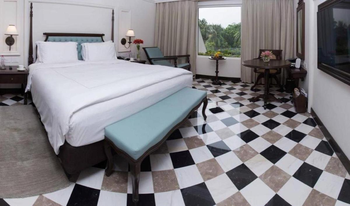 a bedroom with a bed and a checkered floor at Taj Bengal in Kolkata