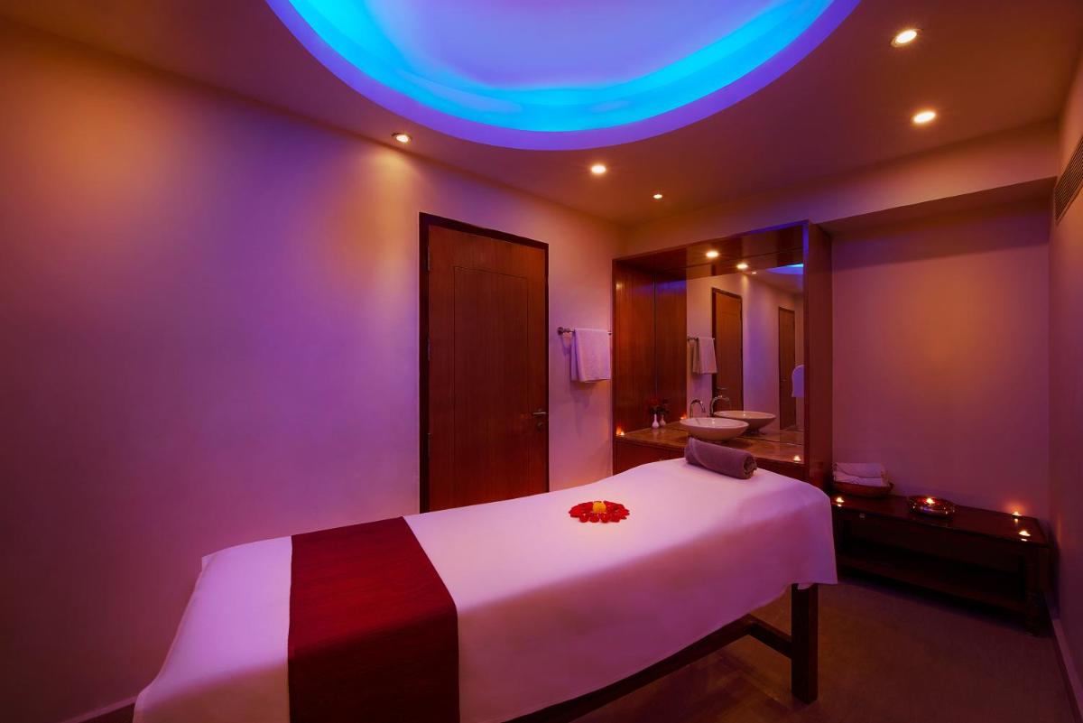 a bedroom with a white bed with a purple ceiling at Accord Puducherry in Puducherry