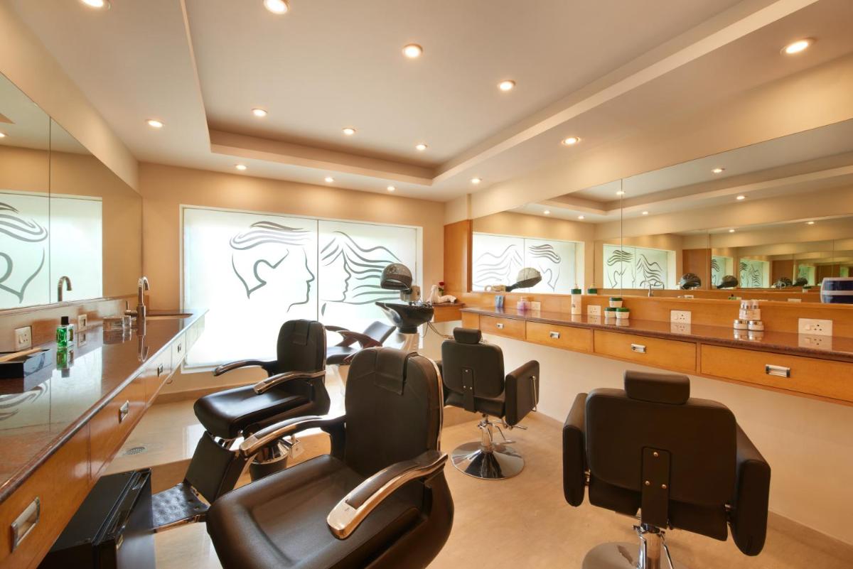 a barber shop with a hair salon with chairs at Accord Puducherry in Puducherry