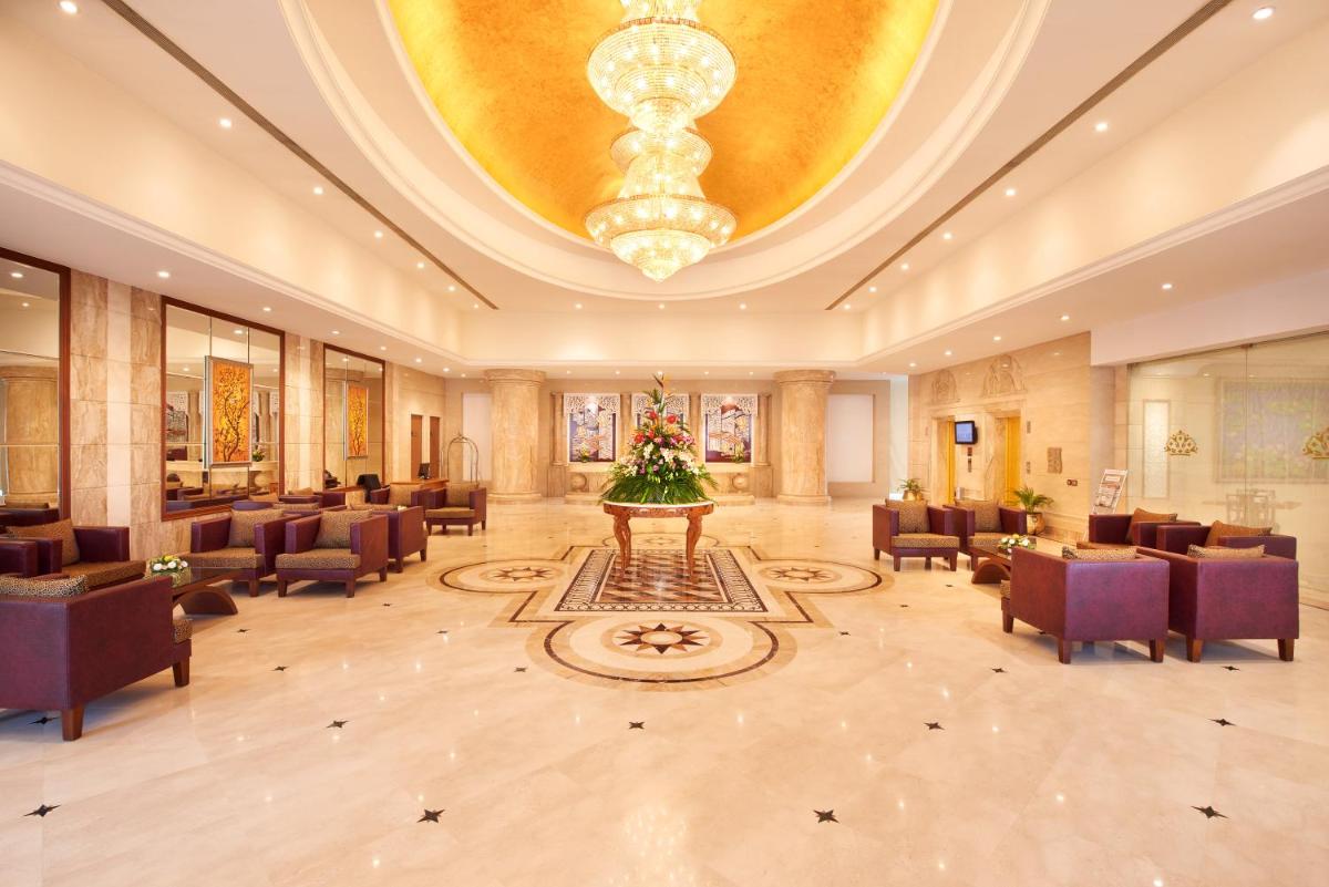 a large lobby with chairs and a large chandelier at Accord Puducherry in Puducherry +29 photos