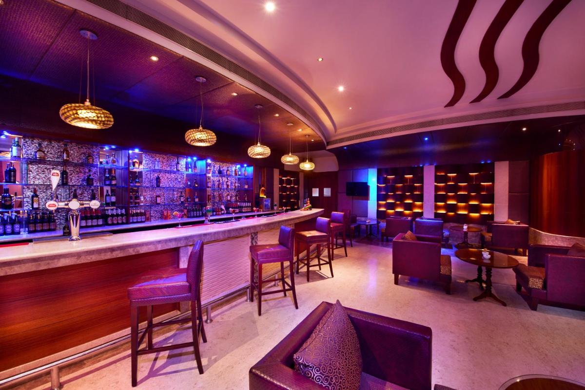 a bar at a restaurant with purple lighting at Accord Puducherry in Puducherry