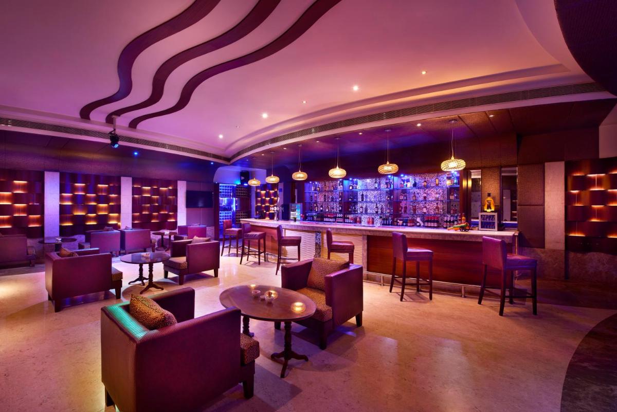 a bar in a restaurant with purple lighting at Accord Puducherry in Puducherry