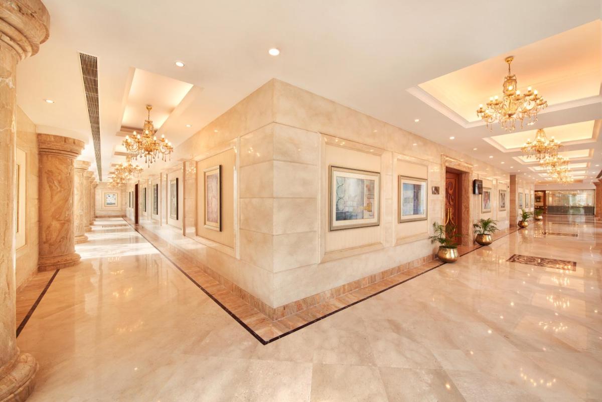 an empty hallway with chandeliers in a building at Accord Puducherry in Puducherry