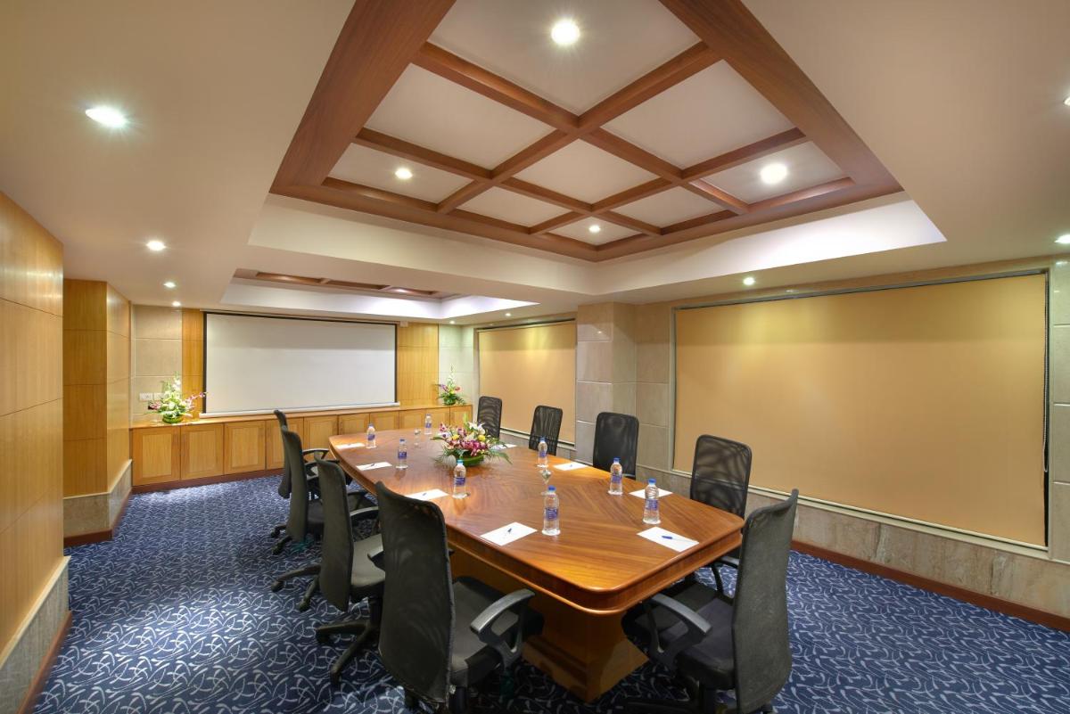 a conference room with a large wooden table and chairs at Accord Puducherry in Puducherry