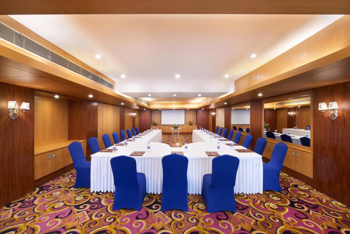 a conference room with a long table and blue chairs at Accord Puducherry in Puducherry