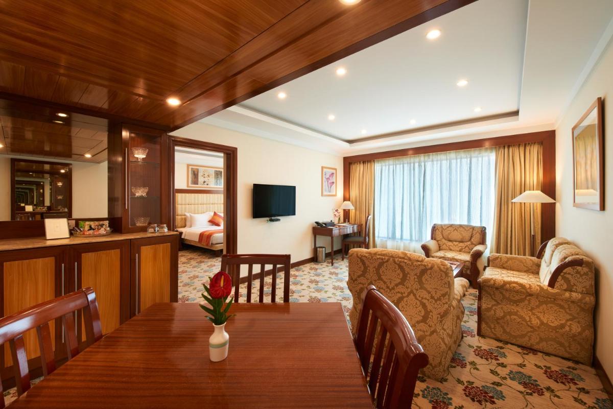 a room with a dining table and a living room at Accord Puducherry in Puducherry