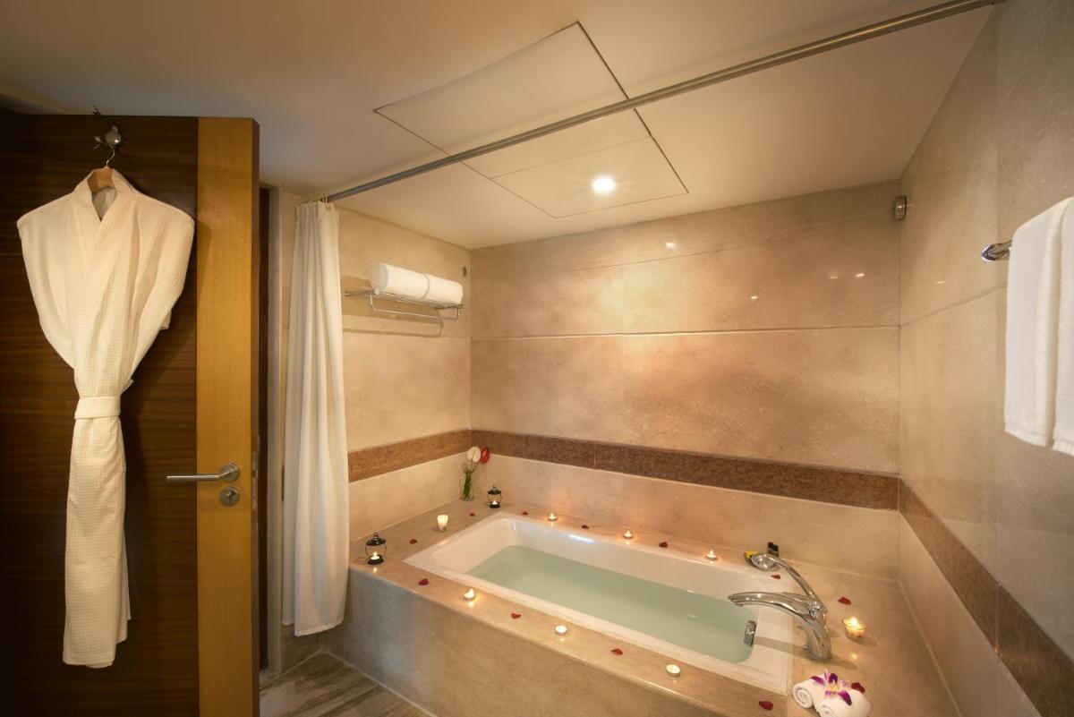 a bathroom with a bath tub with a sink at Accord Puducherry in Puducherry