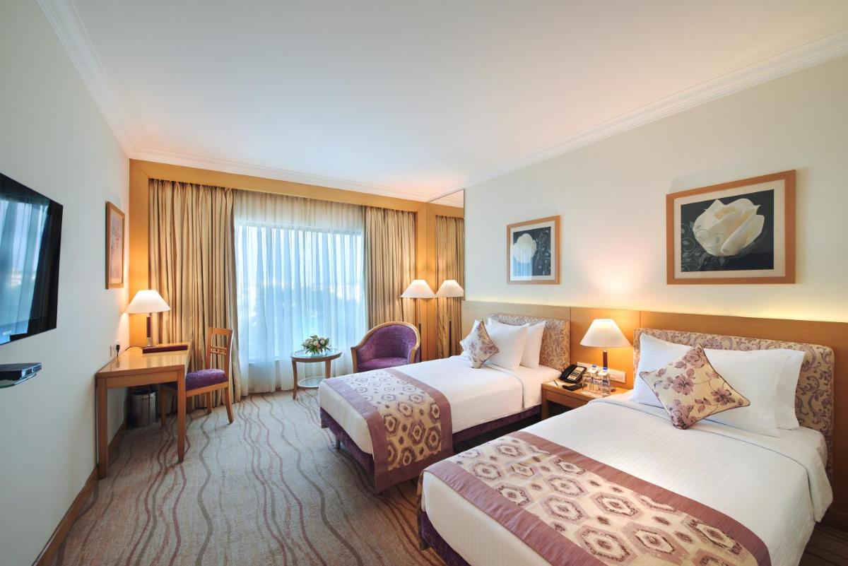 a hotel room with two beds and a television at Accord Puducherry in Puducherry