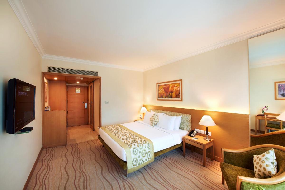 a hotel room with a bed and a chair at Accord Puducherry in Puducherry