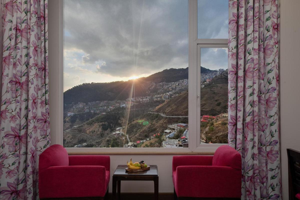 a window with a view of a mountain at The Orchid Shimla in Shimla