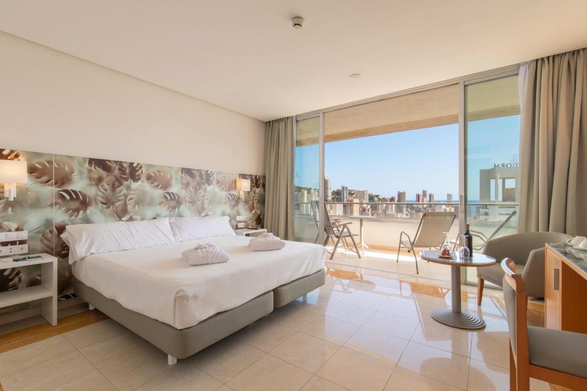 Un dormitorio con una cama y un balcón. en Hotel BCL Levante Club & Spa 4 Sup - Only Adults Recomended, en Benidorm