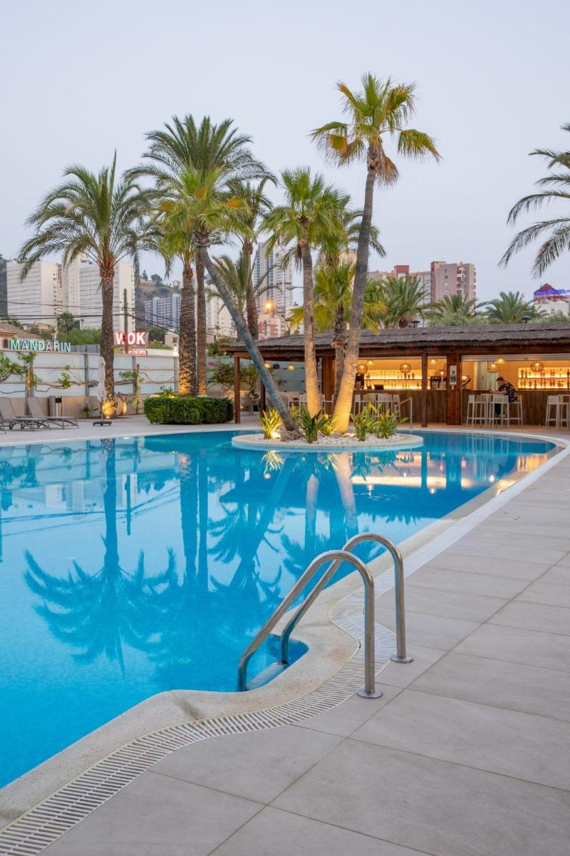 una piscina con palmeras en un resort en Hotel BCL Levante Club & Spa 4 Sup - Only Adults Recomended, en Benidorm