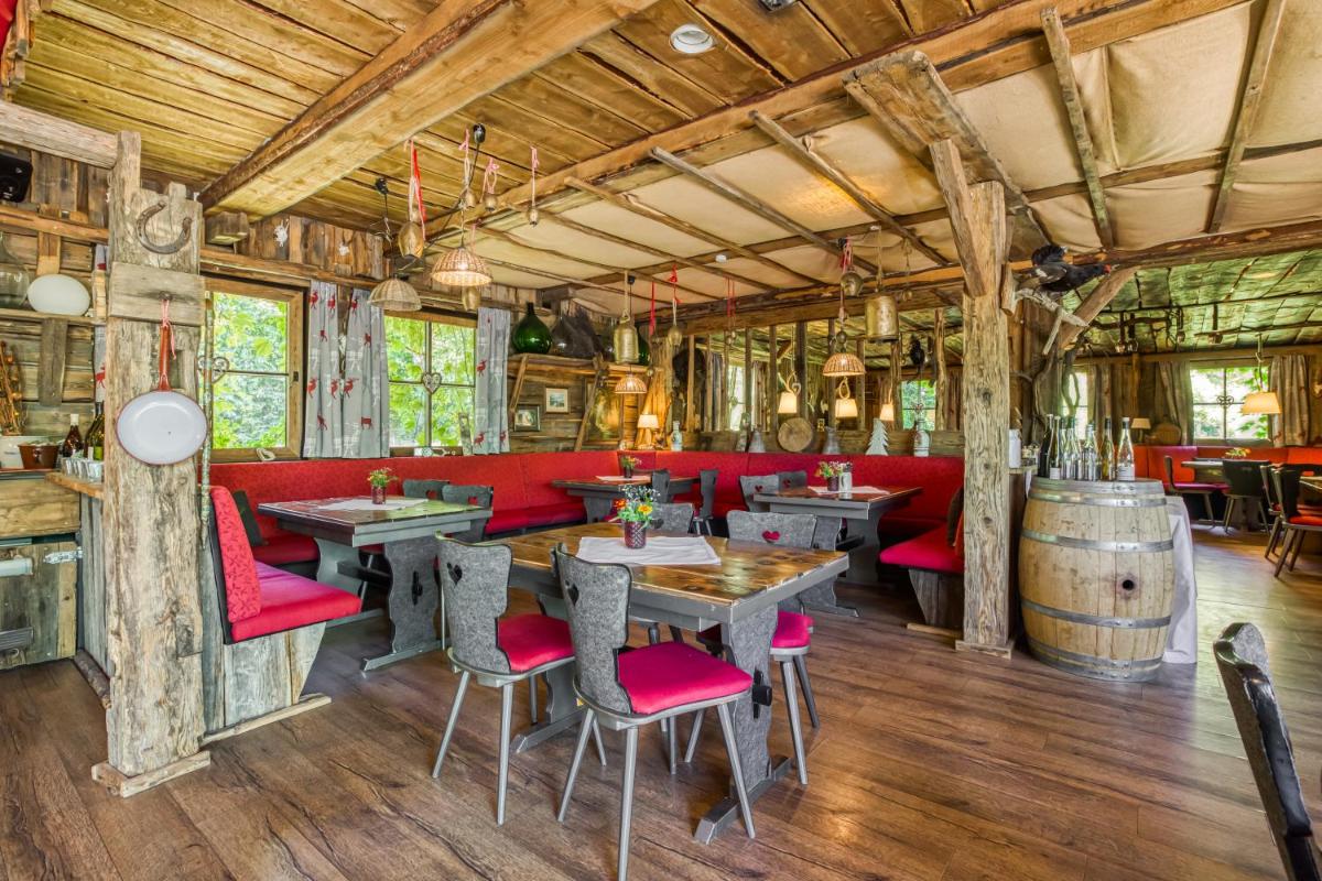 ein Restaurant mit roten Stühlen und Tischen und einem Weinfass in der Unterkunft Wald & Schlosshotel Friedrichsruhe in Friedrichsruhe