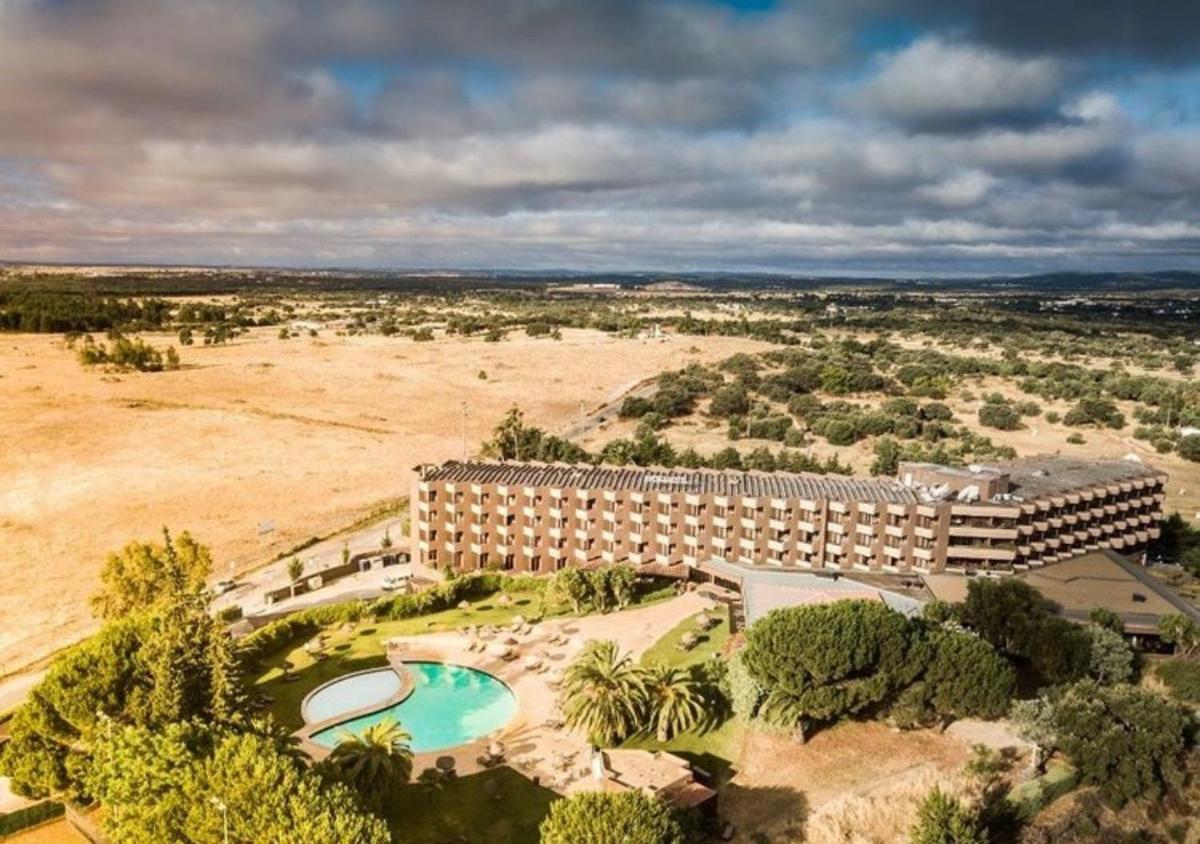 Vista aérea de um resort com piscina em Evora Hotel em Évora