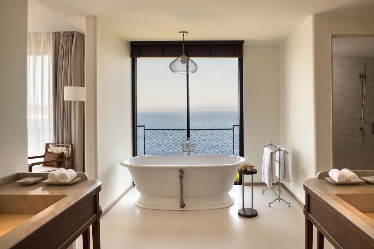 Un baño con bañera con vista al mar. en Six Senses Ibiza, en Portinatx