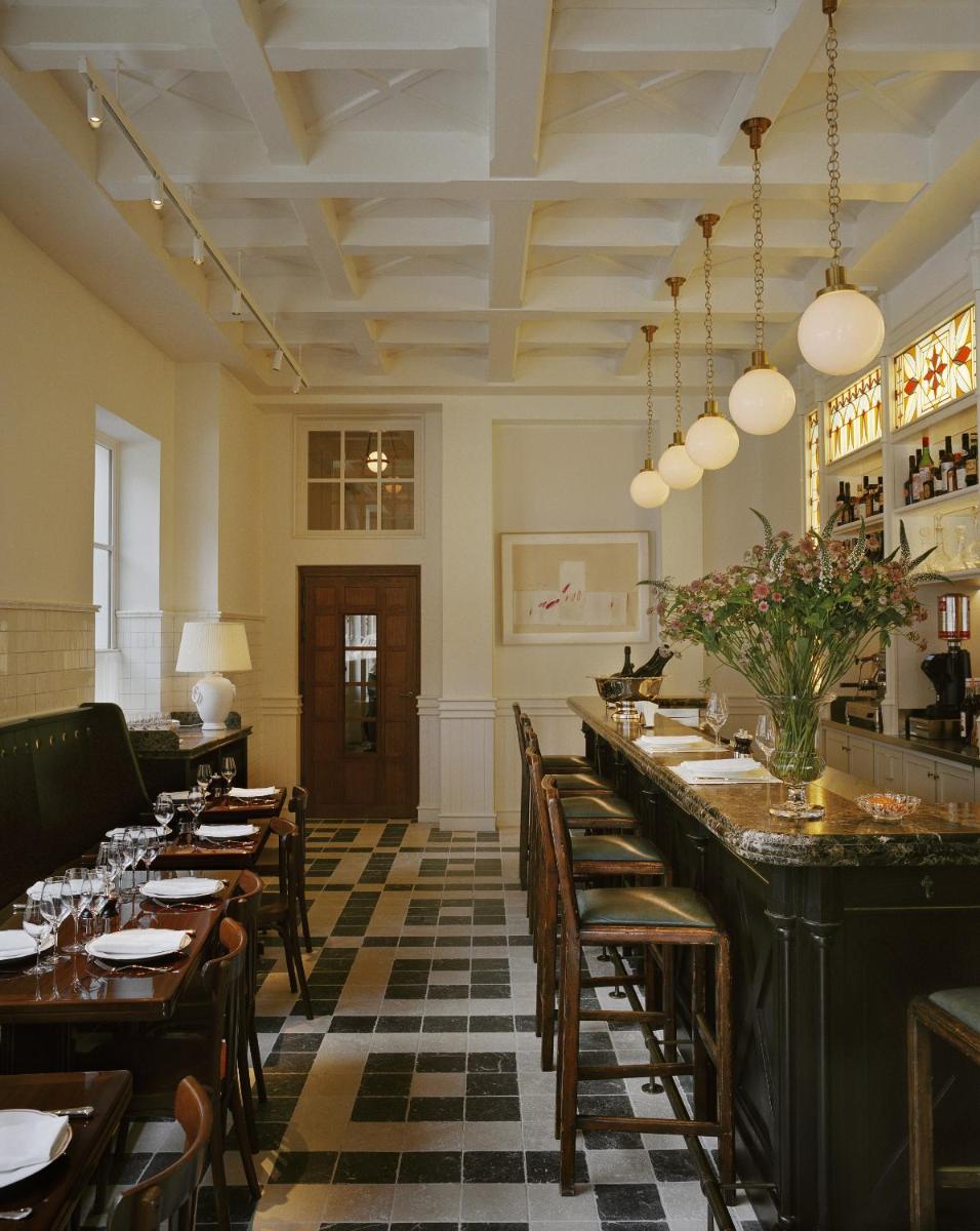un restaurant avec un long bar doté de tables et de chaises dans l'établissement Château Voltaire, à Paris