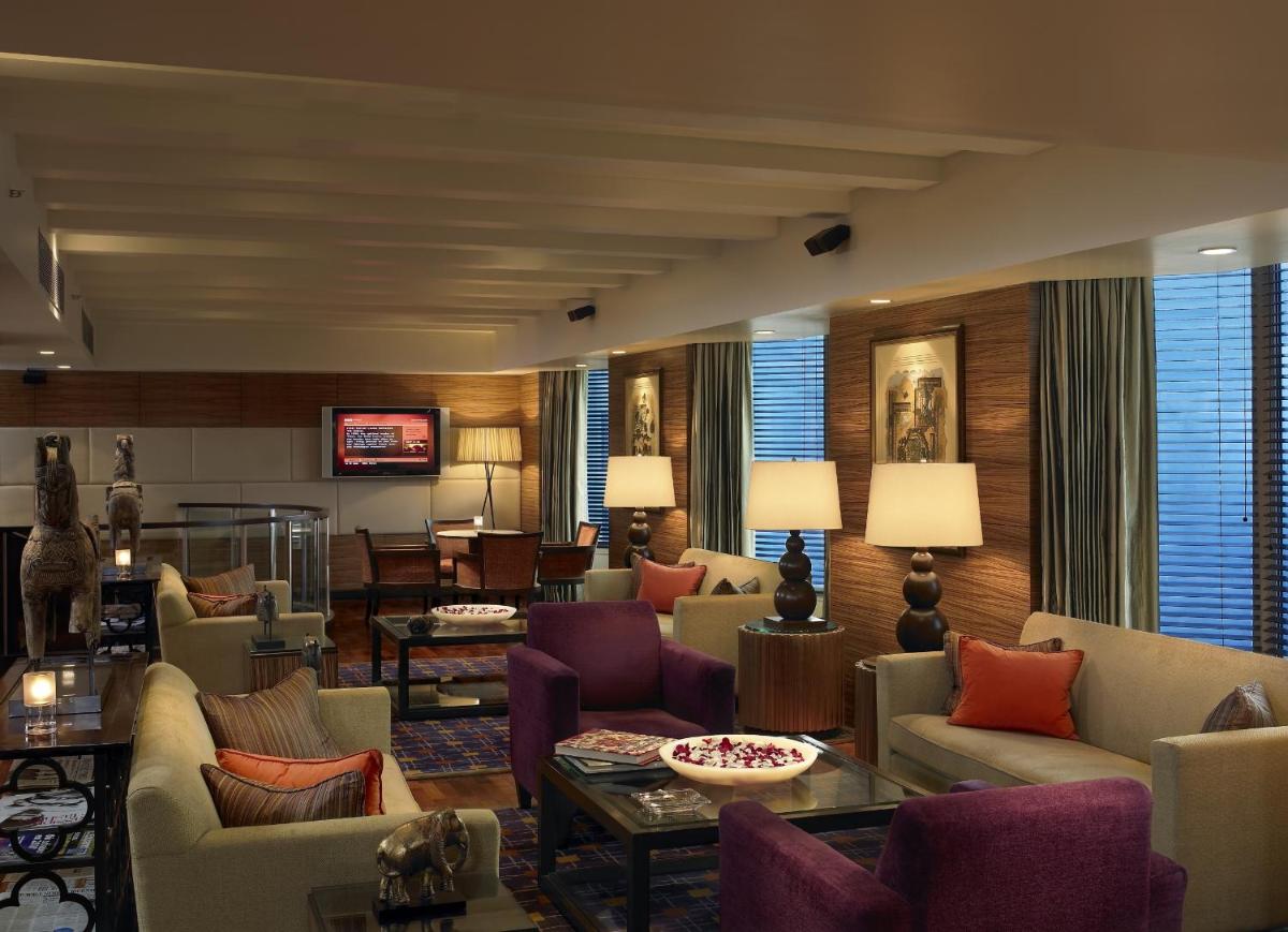 a living room with couches chairs and a table at The Leela Mumbai in Mumbai a living room with couches chairs and a table at The Leela Mumbai in Mumbai