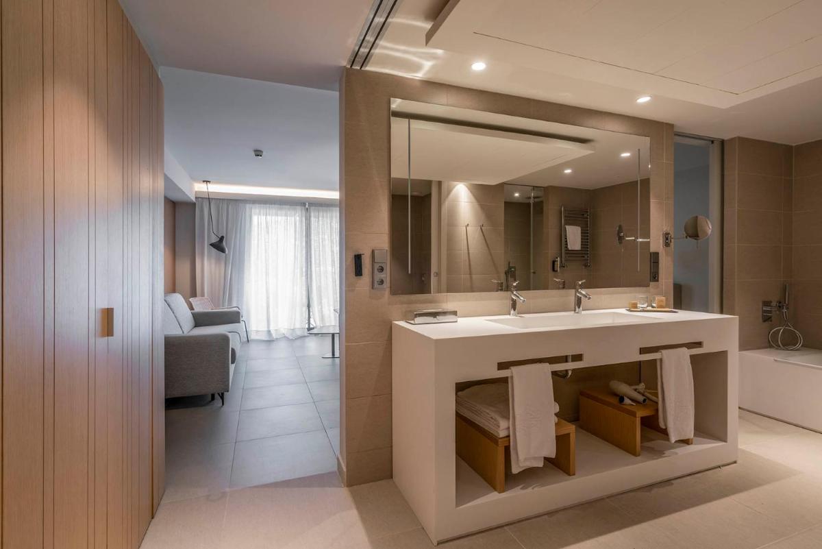 Un baño con lavabo y un espejo grande. en Parador de Aiguablava, en Begur