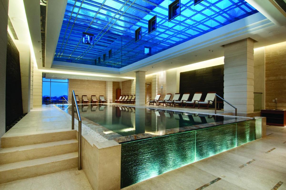 a swimming pool in a building with a glass ceiling at Hyatt Regency Pune Hotel & Residences in Pune a swimming pool in a building with a glass ceiling at Hyatt Regency Pune Hotel & Residences in Pune