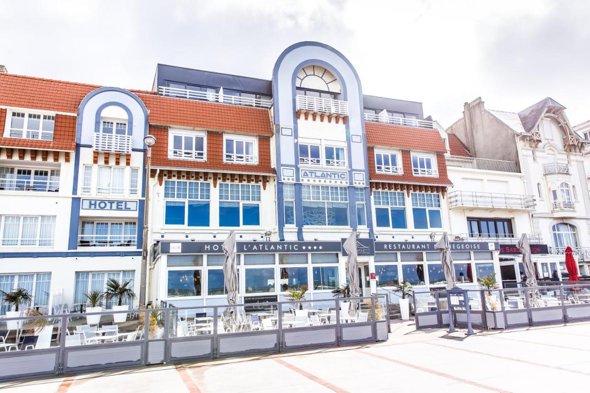 un grand bâtiment bleu et blanc dans l'établissement Hotel Atlantic, à Wimereux