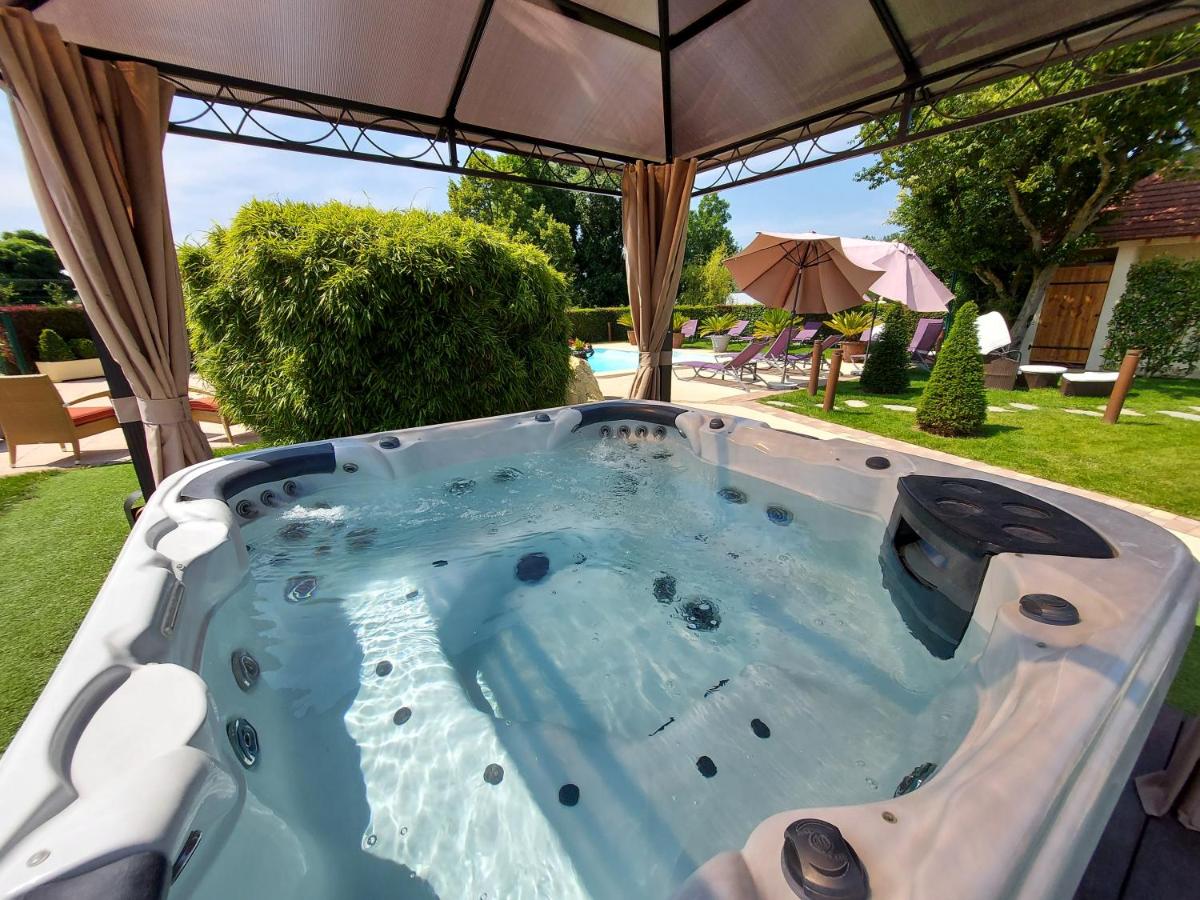 - un bain à remous dans la cour avec un parasol dans l'établissement Hôtel du Domaine de La Grange de Condé, à Condé-Northen