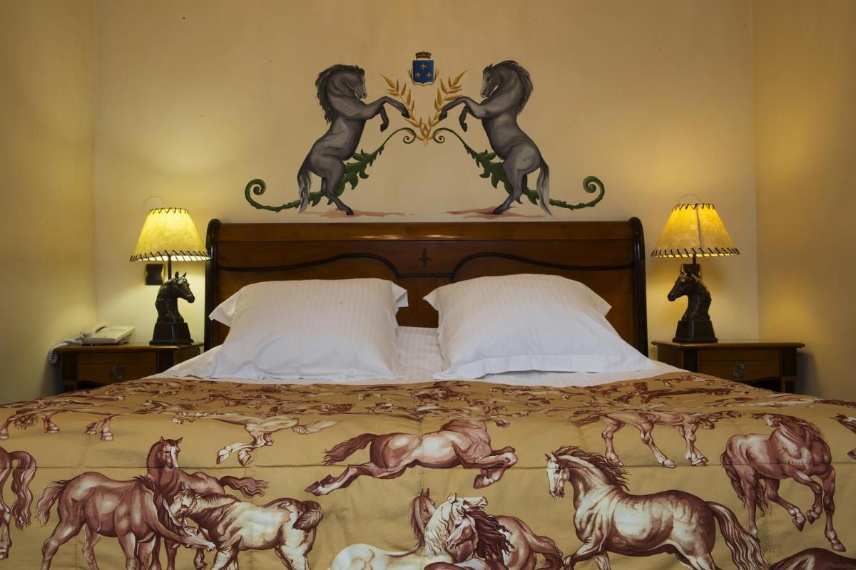 Un ou plusieurs lits dans un hébergement de l'établissement Hôtel du Domaine de La Grange de Condé
