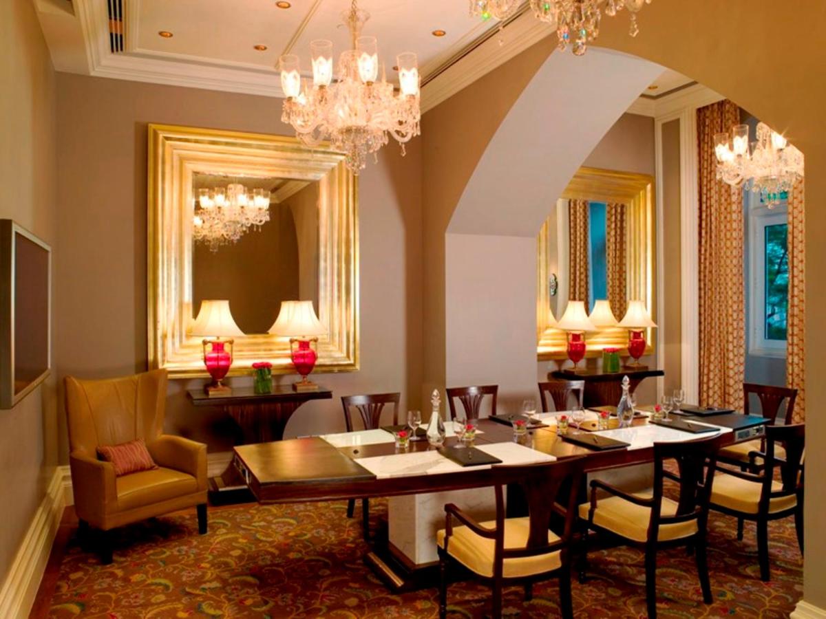 a dining room with a table and chairs and chandeliers at The Taj Mahal Tower, Mumbai in Mumbai a dining room with a table and chairs and chandeliers at The Taj Mahal Tower, Mumbai in Mumbai
