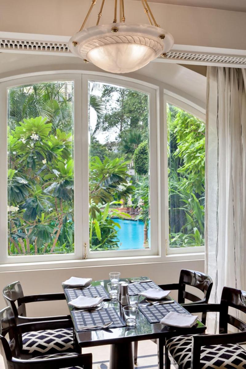 a dining room with a table and two windows at The Taj Mahal Tower, Mumbai in Mumbai a dining room with a table and two windows at The Taj Mahal Tower, Mumbai in Mumbai