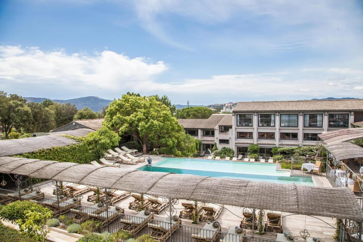 une vue aérienne d'un complexe hôtelier avec une piscine et un bâtiment dans l'établissement Hôtel Le Roi Théodore & Spa, à Porto-Vecchio