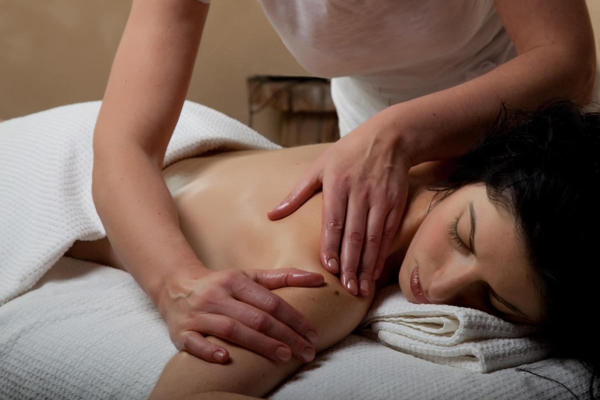 une femme recevant un massage d'un thérapeute dans l'établissement La Solenzara hôtel - 3 Etoiles Supérieur - Appartement & SPA, à Sari-Solenzara
