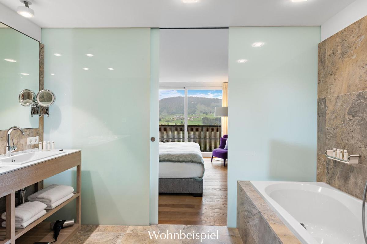 ein Badezimmer mit Badewanne und ein Schlafzimmer in der Unterkunft Allgäu Sonne in Oberstaufen