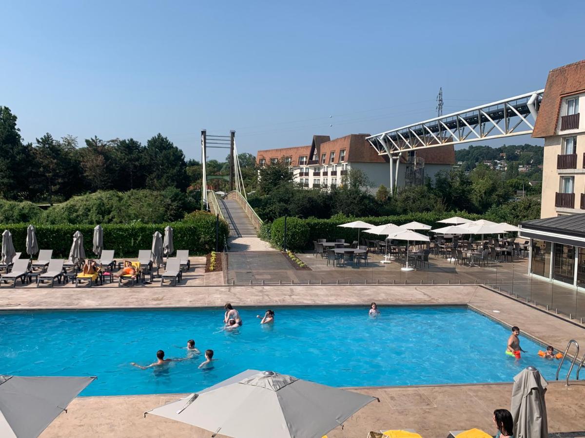 un groupe de personnes nageant dans une piscine dans l'établissement Amirauté Hôtel Golf Deauville, à Deauville