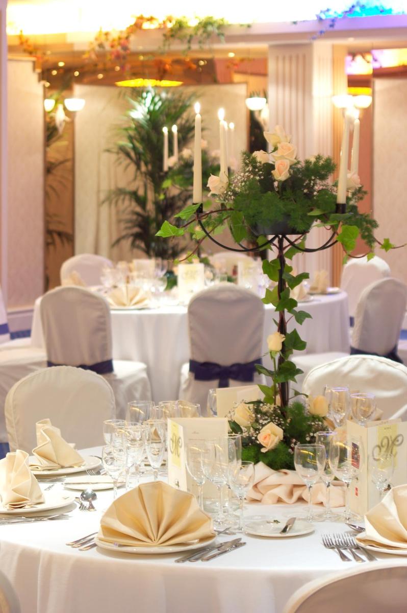 una mesa con mesas blancas con flores y velas en Hotel RIU Garoé, en Puerto de la Cruz 36 fotos más