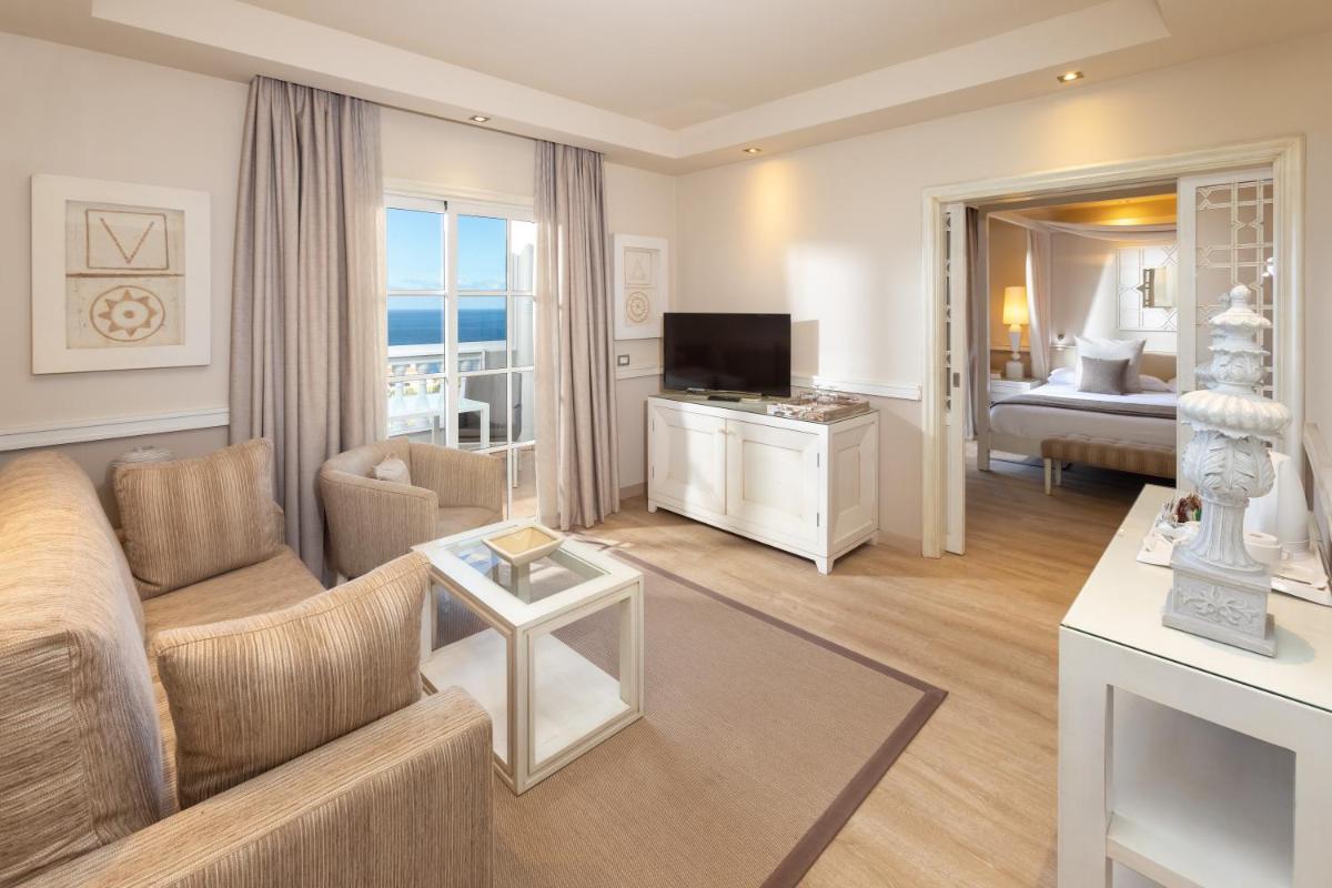 Una sala de estar con un sofá y un televisor. en Hotel RIU Garoé, en Puerto de la Cruz