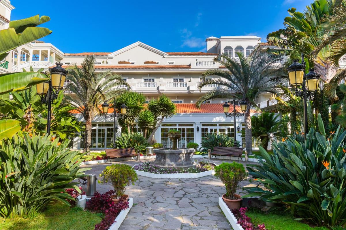 un complejo con una fuente y palmeras en Hotel RIU Garoé, en Puerto de la Cruz