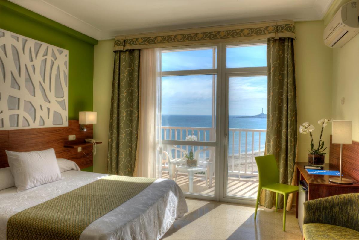 Un dormitorio con una cama y vista al mar. en Hotel & Spa Entremares, en La Manga del Mar Menor