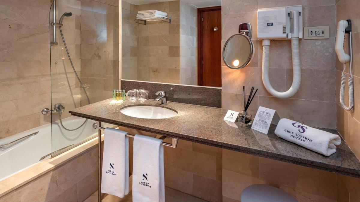 Un baño con lavabo, ducha y espejo. en Gran Hotel Rey Don Jaime, en Castelldefels