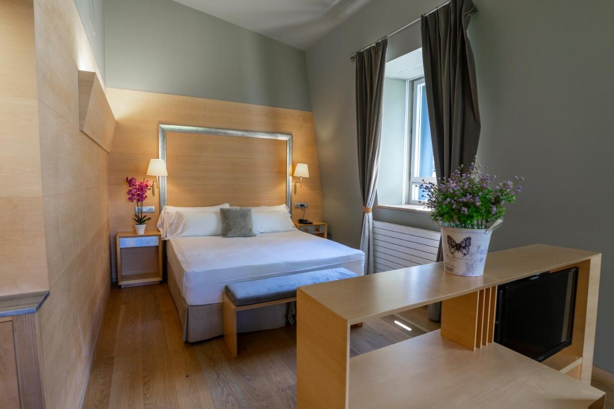 Una habitación de hotel con una cama y una ventana. en Gran Hotel – Balneario de Panticosa, en Panticosa