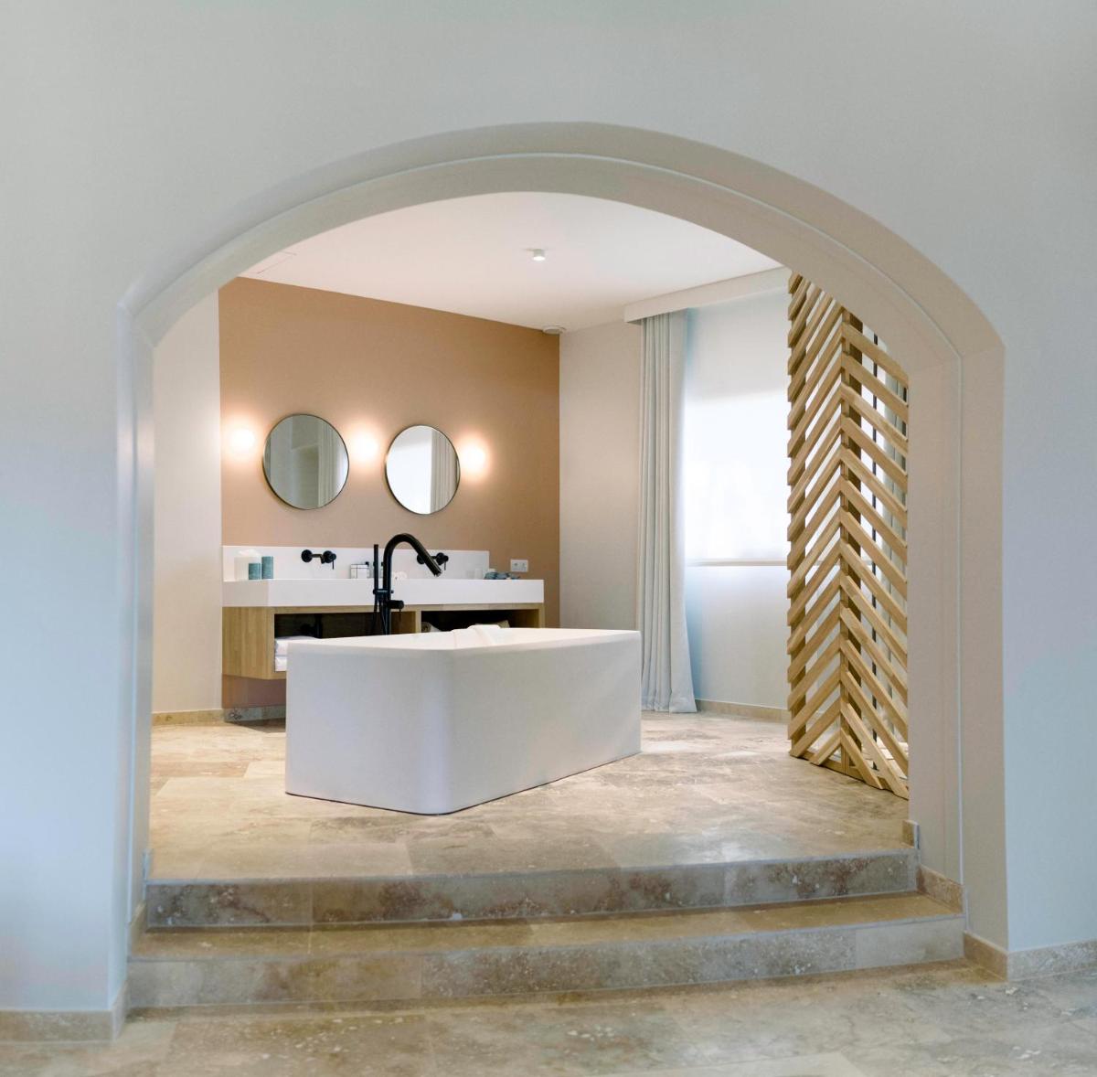 une salle de bain avec une baignoire blanche et un lavabo dans l'établissement Château L'Hospitalet Wine Resort Beach & Spa, à Narbonne