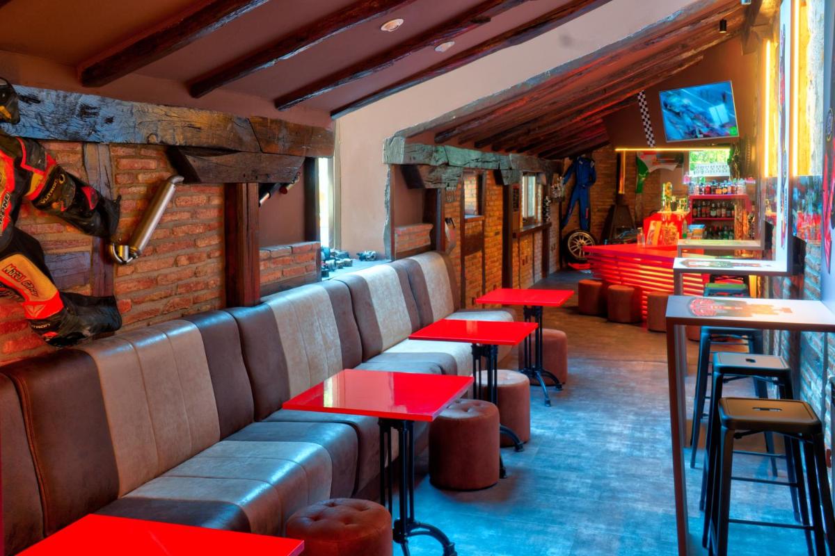un restaurante con mesas rojas y un bar en Costa Esmeralda Suites, en Suances