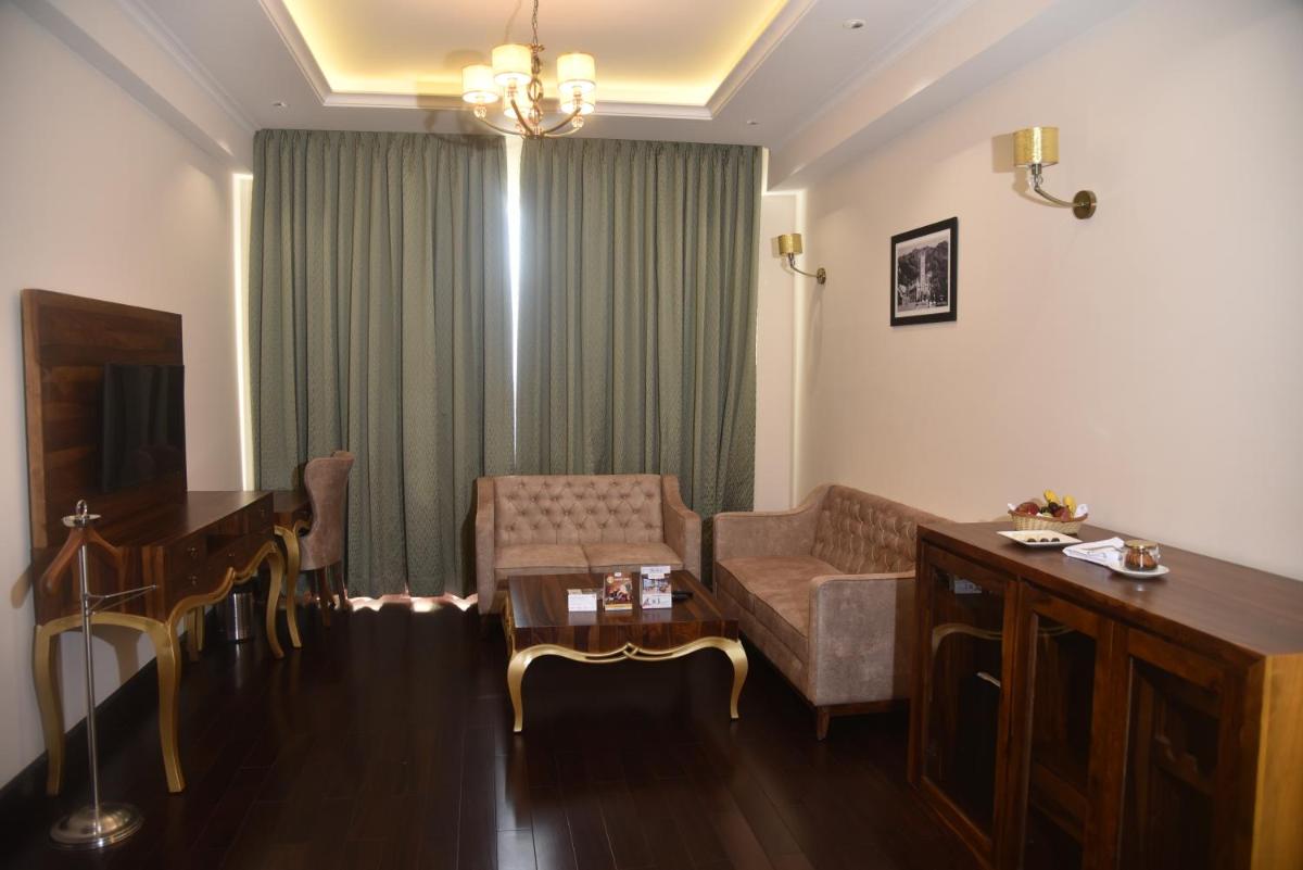a living room with a couch and a table at The Orchid Shimla in Shimla
