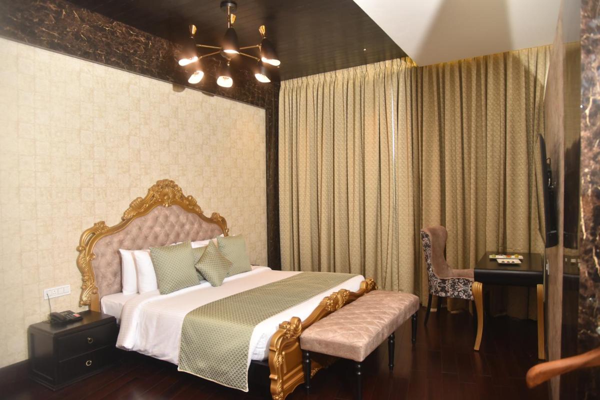 a bedroom with a large bed and a chair at The Orchid Shimla in Shimla