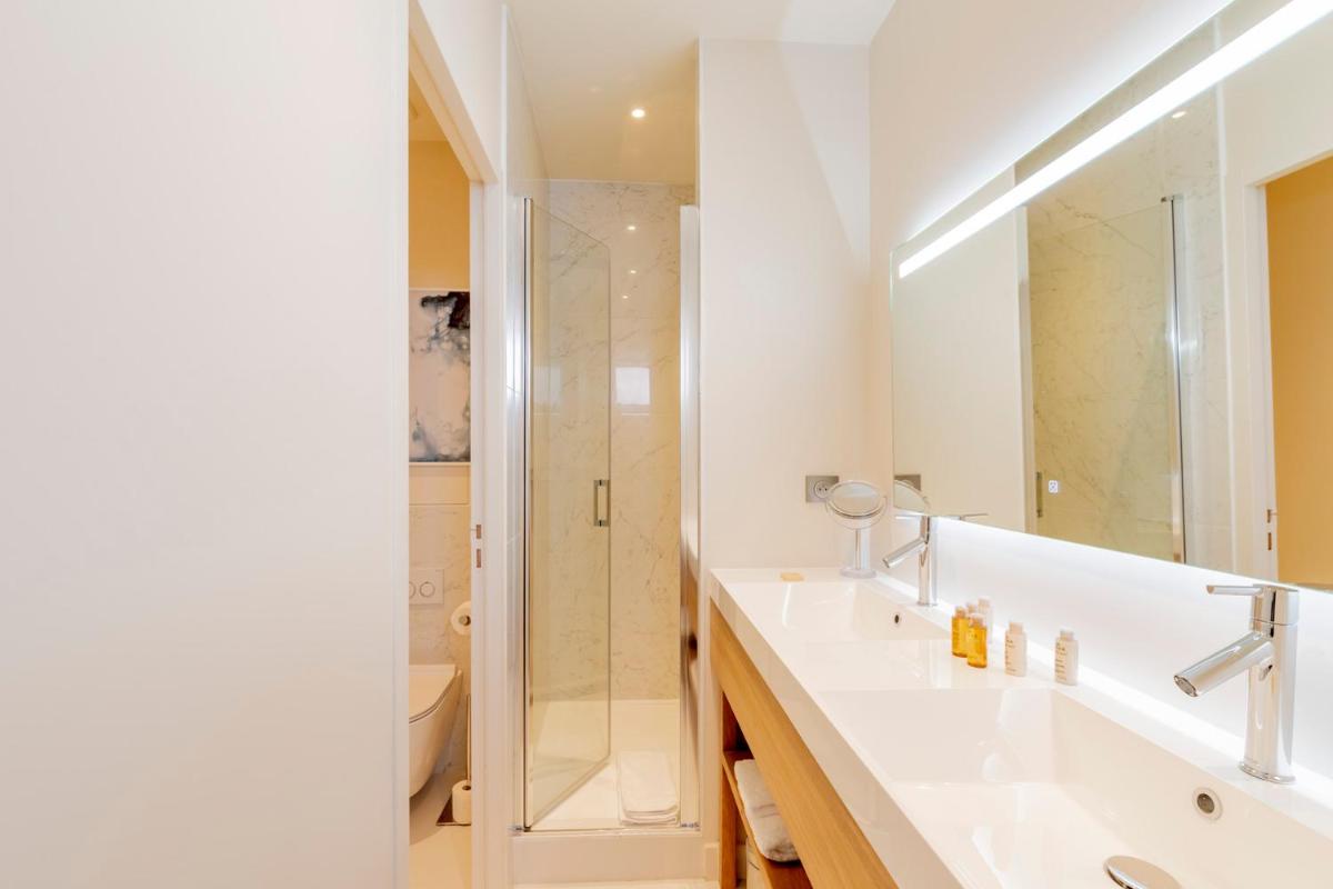 une salle de bain avec un lavabo et une douche dans l'établissement Résidence Les Suites du Port - by Le Saint Ferdinand, à Arcachon 23 autres photos
