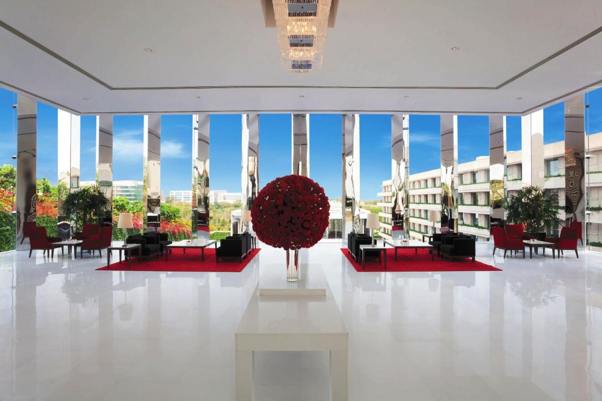 a lobby with tables and chairs and a giant red ball at The Oberoi Gurgaon in Gurgaon